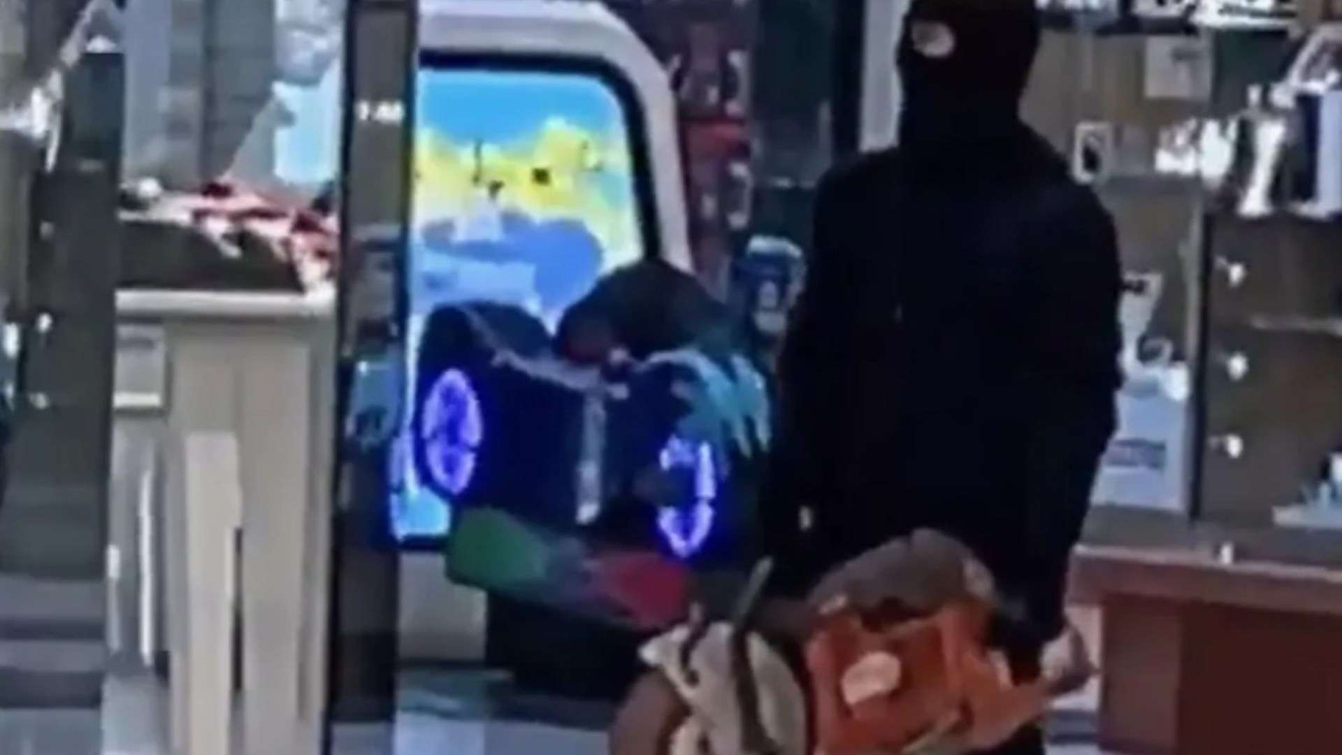Shock moment robber brandishes circular saw in shopping centre after masked gang storm jewellery stores