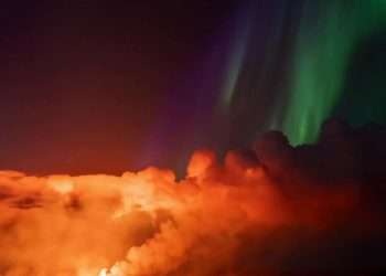 Northern Lights seen glowing in the night sky as volcanic lava spews in incredible footage from Iceland
