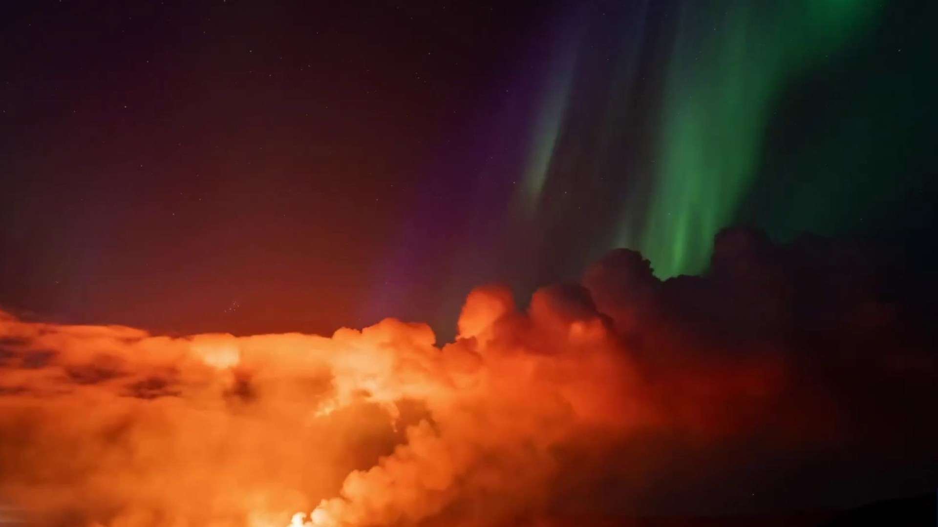 Northern Lights seen glowing in the night sky as volcanic lava spews in incredible footage from Iceland