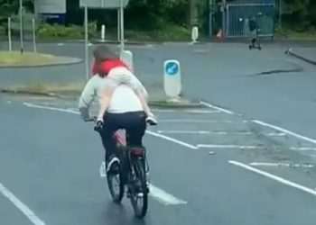 Shocking moment cyclist tears through traffic with child clinging to back – before riding WRONG way through roundabout